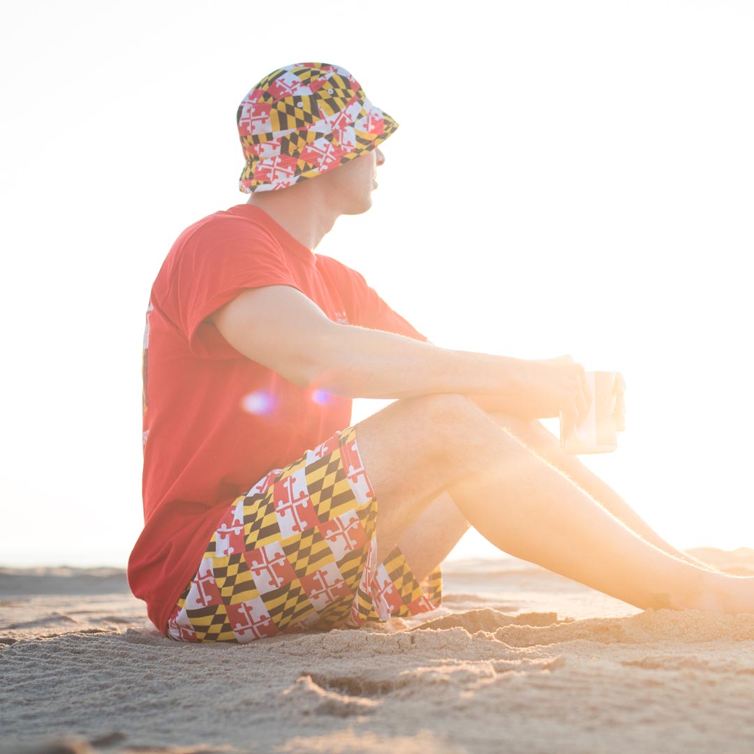Person sitting on the beach wearing Maryland My Maryland clothing